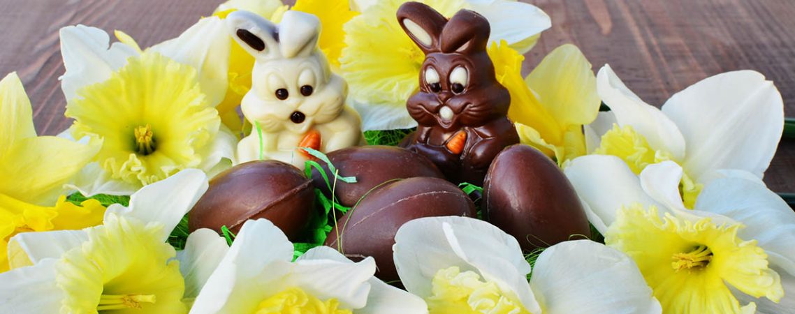 Schokoladenosterhasen, umgeben von Schokoladeneiern für Kinder