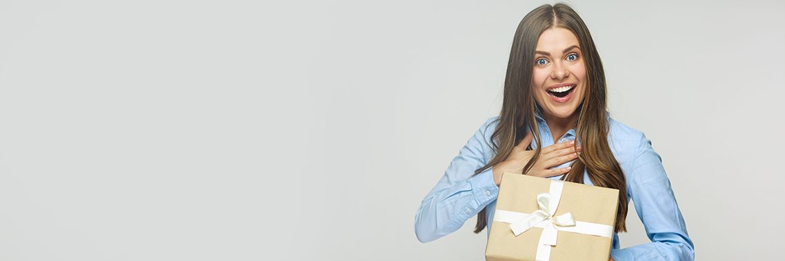 Happy business woman holding gift box.